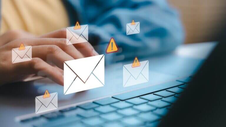 Hands,Typing,On,A,Laptop,With,Warning,Email,Icons,,Representing